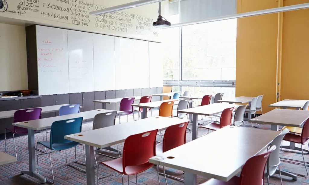 empty classroom filled with desks and colourful school chairs
